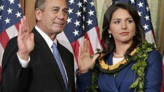 Rep. Tulsi Gabbard, the first Hindu in Congress, participates in a ceremonial swearing-in administered by Speaker of the House Rep. John Boehner.